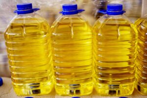 vegetable seed oils 300x200 - Close up view of three big transparent plastic bottles with blue