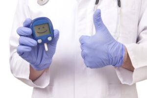 reversing managing diabetes on low carbs 300x200 - Doctor holding blood sugar meter. Showing OK sign