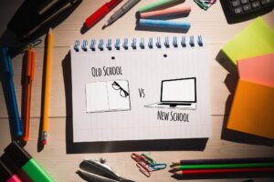 old school new school 300x200 - old school vs new school  against students table with school supplies